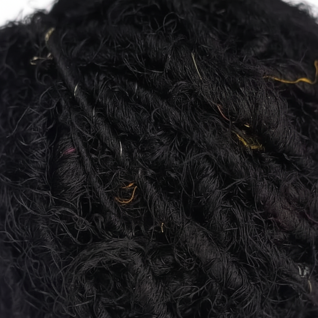 Close-up macro texture of black recycled sari silk yarn fibers