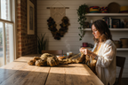 Lifestyle image of woman knitting with KNITSILK earthy brown and olive recycled sari silk ribbon yarn in a rustic bohemian studio